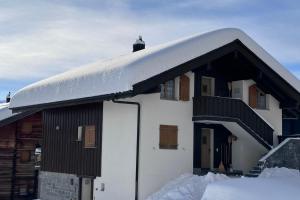 a snow covered roof of a house with snow on it at Serenella Apartment in Riederalp