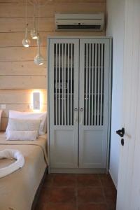 a bedroom with a bed and a white closet at Auberge Kalopetri in Kamiros