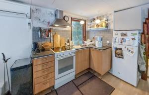 una cucina con frigorifero bianco e piano cottura forno superiore di Amazing Home In Hr With Kitchen a Höör