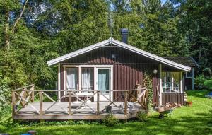 a small cabin with a deck in the grass at Amazing Home In Hr With Kitchen in Höör