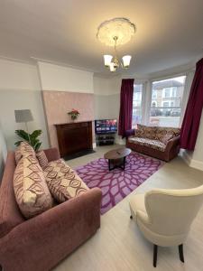 een woonkamer met een bank en een open haard bij Newly renovated, spacious East London home in Seven Kings