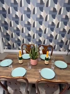 a wooden table with chairs and plates and bottles at Newly renovated, spacious East London home in Seven Kings