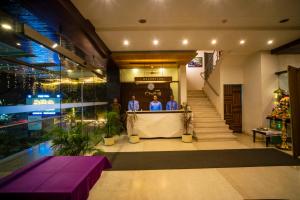 un grupo de personas de pie en un mostrador en un edificio en Hotel Chaitali - Pure Veg, en Kolhapur