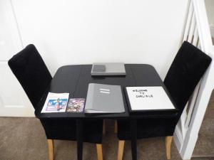 a black table with two chairs and a laptop on it at Family Home Near City Centre - New KING bed! in Carlisle +40 photos