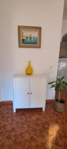 un armario blanco en una habitación con una planta en Chez Marlene, en Lagos