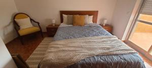 Un dormitorio con una cama, una silla y una ventana en Chez Marlene, en Lagos