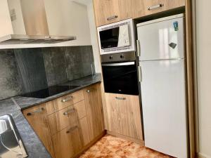Una cocina con un refrigerador blanco y un microondas. en Casa Azañas, en Casavieja