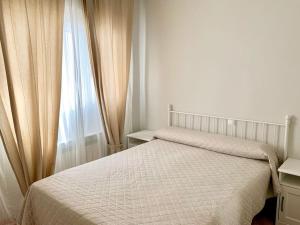 1 dormitorio con cama blanca y ventana en Casa Azañas, en Casavieja