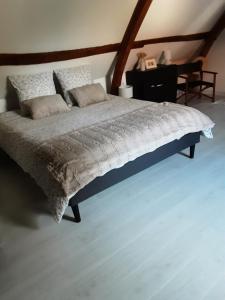 a bedroom with a large bed with a wooden headboard at La grange de Fermont in Capelle-Fermont