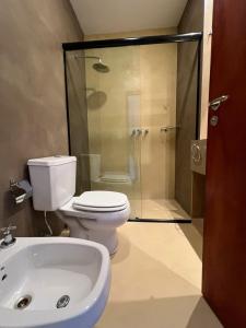 a bathroom with a shower and a toilet and a sink at Hotel Cerros del Norte in Tilcara