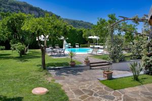 - un jardin avec une piscine, une table et des chaises dans l'établissement Amore Rentals - Casa Limoneto, à Sorrente