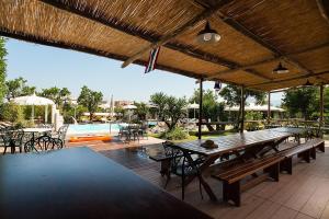 une terrasse avec des tables et des chaises en bois et une piscine dans l'établissement Amore Rentals - Casa Limoneto, à Sorrente