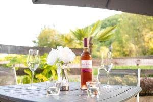 a bottle of wine sitting on a table with glasses at Gites spa de charme L ETOILE SPA in Beynac-et-Cazenac