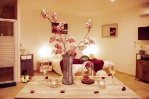 a table with a vase with flowers in a living room at Gites spa de charme L ETOILE SPA in Beynac-et-Cazenac