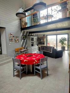 a living room with a red table and chairs at La maison du colibri 