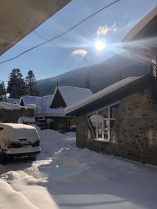 a snow covered house with a car parked in front of it at Hotel Chateau in Bukovel