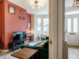 uma sala de estar com um sofá verde e uma parede vermelha em Pass the Keys Belmont Bolthole 2 Bed Bars and Eateries Abound em Belfast