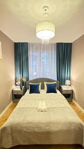 Schlafzimmer mit einem großen Bett und blauen Vorhängen in der Unterkunft My Beloved Warsaw Żurawia Street in Warschau