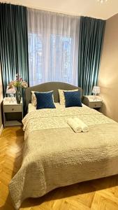Schlafzimmer mit einem großen Bett und blauen Vorhängen in der Unterkunft My Beloved Warsaw Żurawia Street in Warschau