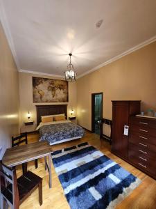1 dormitorio con cama, mesa y alfombra en Casa Hibiscus Boutique Hotel, en Cuenca