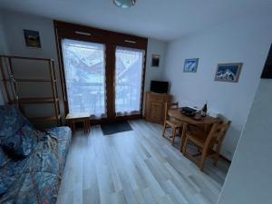 uma sala de estar com um sofá e uma mesa em Studio pieds des pistes plein soleil em Les Contamines-Montjoie