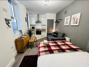 a bedroom with a bed and a living room at Cosy Studio near the City Centre in Liverpool