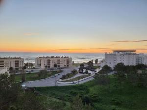 a road in a city with buildings and the ocean at Quinta das Rosas - Beach and Mountain apartment in Buarcos