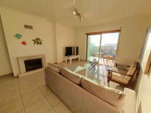 uma sala de estar com um sofá e uma lareira em Quinta das Rosas - Beach and Mountain apartment em Buarcos
