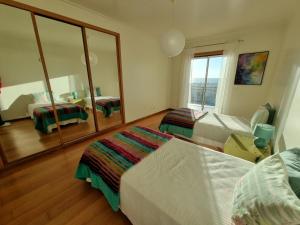 a bedroom with two beds and a mirror at Quinta das Rosas - Beach and Mountain apartment in Buarcos +45 photos