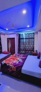 a bedroom with two beds and a blue ceiling at Shillong Guest House in Shillong