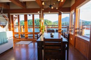 a dining room with a table and some windows at Waterfront Condo in Ucluelet in Ucluelet