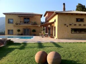 a house with two large stone spheres in the yard at Villa Daphne Private Pool & Amazing View in Dhamiá