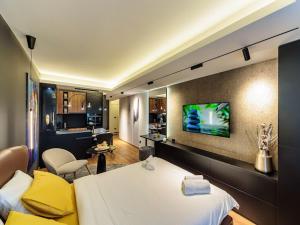 ein Hotelzimmer mit einem Bett und einem TV an der Wand in der Unterkunft Butterfly in Kragujevac