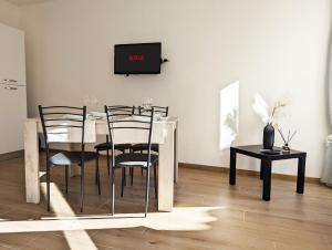 a dining room with a table with chairs and a tv at Assisi Suite Relax, Bilocale nel centro storico in Assisi