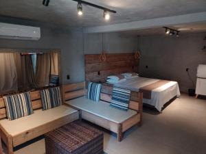 ein Schlafzimmer mit einem Bett und zwei Bänken darin in der Unterkunft Caixa D'aço Exclusive Hotel in Porto Belo