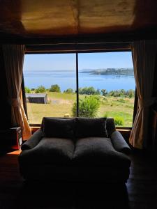 a couch in a room with a large window at Casa Carlota in Futrono