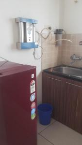 a small kitchen with a sink and a refrigerator at WeKare Archid Royal Service Apartment in Bhubaneshwar