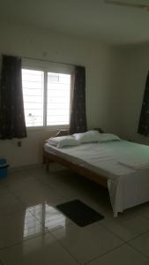a bedroom with a large bed with a window at WeKare Archid Royal Service Apartment in Bhubaneshwar