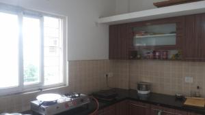 a kitchen with a stove and a window in it at WeKare Archid Royal Service Apartment in Bhubaneshwar