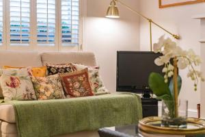 a living room with a couch and a tv at Villa Vita - Ideally located cottage by the sea in Deal