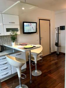 uma cozinha com uma mesa e uma televisão na parede em Casa La Mo’ moderno bilocale in zona tranquilla em Cattolica