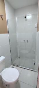 ein weißes Bad mit einer Dusche und einem WC in der Unterkunft Pousada Vale do Café in Miguel Pereira