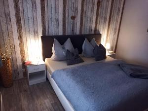 Schlafzimmer mit einem Bett mit blauer Bettwäsche und Kissen in der Unterkunft Pension Danzer in Oberhof