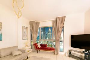 a living room with a couch and a tv and a window at Spectacular Burj & Fountain View - Luxurious 3 Bedrooms & Maids room - The Residences in Dubai