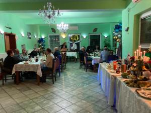 um grupo de pessoas sentadas em mesas em um restaurante em Pensiunea Dragonul em Avrig