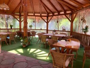 a dining area with tables and chairs in a pavilion at Pensiunea Dragonul in Avrig