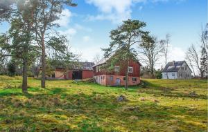 een oude rode schuur in een veld met bomen bij 3 Bedroom Lovely Home In Knred in Knäred