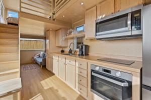 a kitchen with a stove and a microwave at Tiny home near Grand Canyon sleeps 5, epic views! in Flagstaff