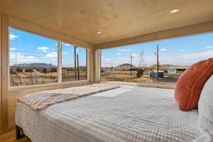 een slaapkamer met een bed en een groot raam bij Tiny home near Grand Canyon sleeps 5, epic views! in Flagstaff