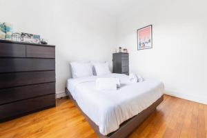 a bedroom with a large bed and a dresser at Appartement Rousseau F2 in Montrouge
